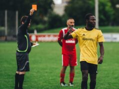 Fier de sa double culture : Ayyoub Bouaddi partage sa fierté après avoir été sélectionné avec l’équipe du Maroc pour la Coupe du monde 2026 Ayyoub Bouaddi en tenue nationale marocaine avec ballon de football derrière lui, souriant devant une arrière-plan de stade.