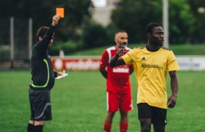 Fier de sa double culture : Ayyoub Bouaddi partage sa fierté après avoir été sélectionné avec l’équipe du Maroc pour la Coupe du monde 2026 Ayyoub Bouaddi en tenue nationale marocaine avec ballon de football derrière lui, souriant devant une arrière-plan de stade.