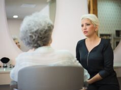 Cheveux Gris : Un Signal Anticancer ? Femme avec cheveux gris assise devant un miroir d'étude
