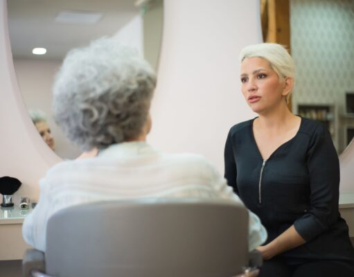 Cheveux Gris : Un Signal Anticancer ? Femme avec cheveux gris assise devant un miroir d'étude