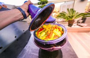 Le ragoût marocain aux patates douces et poulet : une recette traditionnelle pour les 10 derniers jours de Ramadan A colorful Moroccan chicken stew with sweet potatoes served at a festive table filled with family members