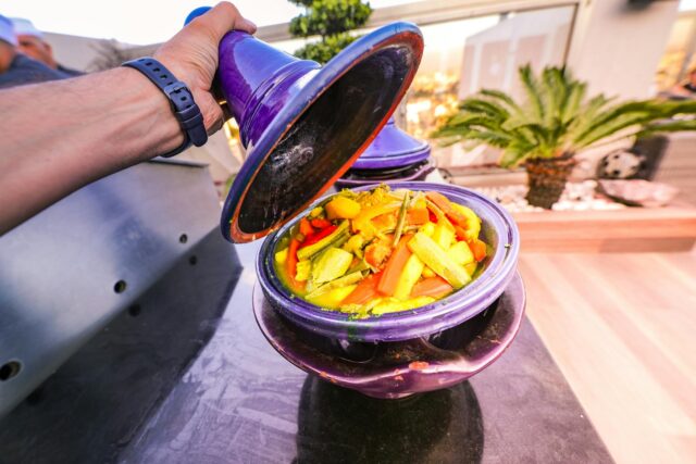 A colorful Moroccan chicken stew with sweet potatoes served at a festive table filled with family members