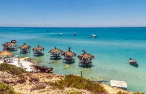 La Tunisie, nouvelle rivale du Maroc sur le marché touristique international Tunisian beach with families enjoying the sun and sea, challenging Moroccan tourism market