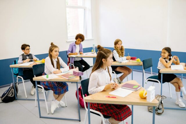 Students from different backgrounds sharing books in a diverse school classroom in Marseille, France
