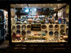 La boutique d’artisanat marocain de Cherbourg-en-Cotentin : découvrir les trésors artisanaux du Maroc Moroccan artisan shop interior with colorful rugs, ceramics, and metalware on display