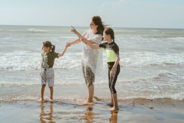 Moroccan family beach Family enjoying beautiful beach in Morocco with crystal clear water and palm trees