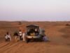 Road trip au Maghreb : itinéraires et conseils A family enjoying a road trip through sunny landscapes in the Maghreb region, featuring stunning views of Morocco and Algeria