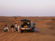 Road trip au Maghreb : itinéraires et conseils A family enjoying a road trip through sunny landscapes in the Maghreb region, featuring stunning views of Morocco and Algeria