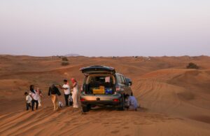 Road trip au Maghreb : itinéraires et conseils A family enjoying a road trip through sunny landscapes in the Maghreb region, featuring stunning views of Morocco and Algeria