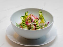 Recette Marocaine Rapide : Salade du Printemps, Une Délicieuse Décision en Version Apéro Salade du Printemps Marocaine avec avocat, tomates et olives sur une assiette de verre à côté d'un plafond marocain