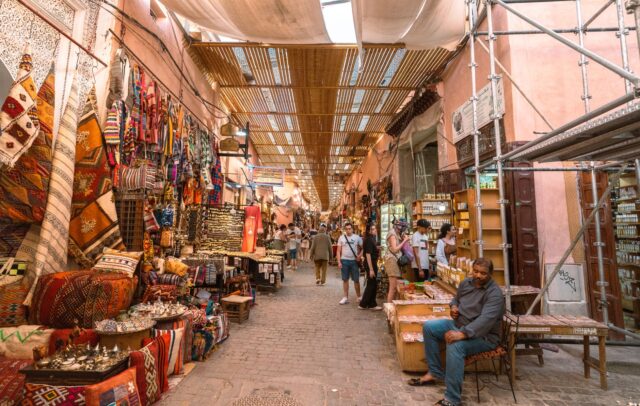 Foreign tourists exploring Marrakech souk market in Morocco