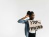 La culture du viol en Tunisie : un problème sous-estimé Tunisienne à l'extérieur d'une cour de justice, holding un affiche anti-violence