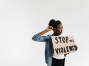 La culture du viol en Tunisie : un problème sous-estimé Tunisienne à l'extérieur d'une cour de justice, holding un affiche anti-violence