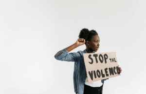 La culture du viol en Tunisie : un problème sous-estimé Tunisienne à l'extérieur d'une cour de justice, holding un affiche anti-violence