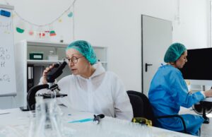 Cheveux gris et défense contre le cancer : une théorie à vérifier Gray-haired woman looking at camera with microscope