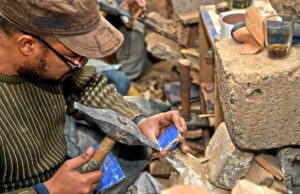L’artisanat marocain à la conquête du monde : les clés pour trouver le bon produit Maroccan artisan at work creating intricate zellige tile patterns for home decor
