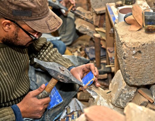 L’artisanat marocain à la conquête du monde : les clés pour trouver le bon produit Maroccan artisan at work creating intricate zellige tile patterns for home decor