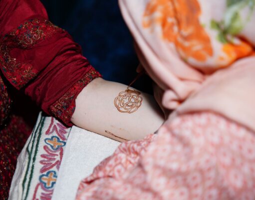 Le henné maghrébin : une pratique culturelle pour la beauté et le bien-être woman applying henna to her hands in a traditional Moroccan setting