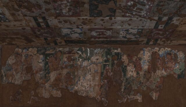 Monks painting a large fresco on the wall in Banon, France, depicting an educational vision for the future