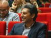 Hicham Lasri au FIRN de Frontignan : l’électron libre du Maroc partage son expérience Hicham Lasri donnant une conférence à FIRN de Frontignan avec un fond bleu et noir représentant les électrons libres