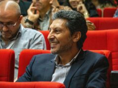 Hicham Lasri au FIRN de Frontignan : l’électron libre du Maroc partage son expérience Hicham Lasri donnant une conférence à FIRN de Frontignan avec un fond bleu et noir représentant les électrons libres