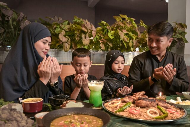 Aïd el-Kébir meal celebration Famille musulmane célébrant la Fête du Sacrifice 2026 avec des ragoûts maghrébins sur une table