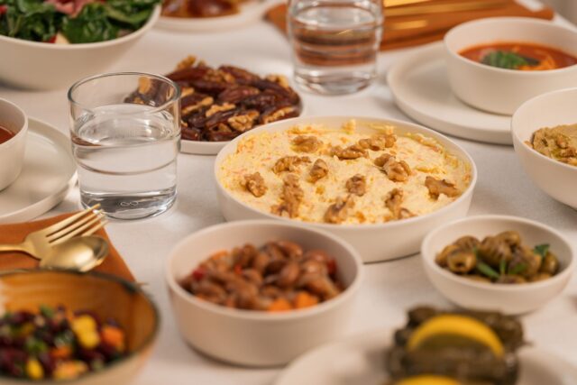 Family enjoying a vegan meal during Ramadan, featuring dishes like lentil stew and roasted vegetables