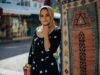 La mode contemporaine pour femme maghrébine : entre tradition et style moderne Femme maghrébine portant un hijab moderne et une robe traditionnelle au milieu d'un marché de textiles