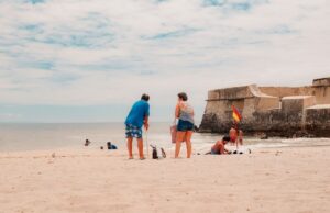 Les meilleures destinations de vacances en Algérie en été : découvrez les joyaux du pays Famille sur la plage en Algérie avec vue sur ruines historiques