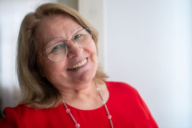 Odile Camus en retrait Madame Odile Camus en retraite, souriant devant l'école de Saint-Hilaire-la-Treille