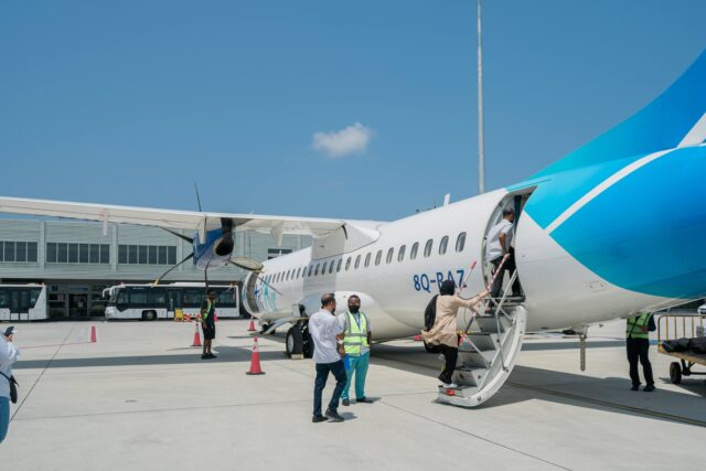 Passengers boarding Air Algérie plane with warm welcome sign