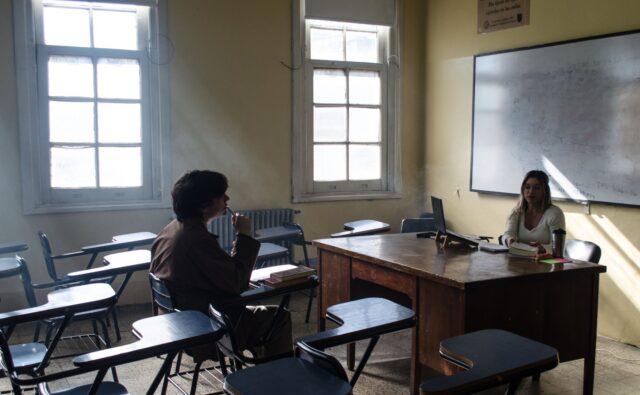 Algérien et Française discutant dans une classe scolaire