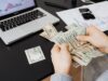 Augmentation du capital de la Société algérienne d’assurance : 299 millions de dollars ! Détails, perspectives et appels à l’action homme d'affaires examinant des documents financiers de la Société algérienne d'assurance avec une monnaie algérienne de 200 d