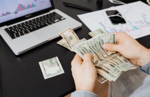 Augmentation du capital de la Société algérienne d’assurance : 299 millions de dollars ! Détails, perspectives et appels à l’action homme d'affaires examinant des documents financiers de la Société algérienne d'assurance avec une monnaie algérienne de 200 d