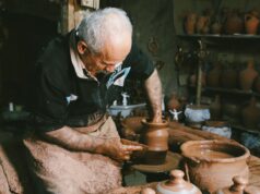 UNESCO célèbre l’excellence de l’artisanat tunisien : découvrez les maîtres artisans et leur héritage Tunisian potter working at his wheel with finished pottery on table