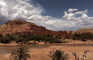 Les oasis marocaines, les trésors cachés du développement durable Moroccan family exploring oasis with sustainable development sign
