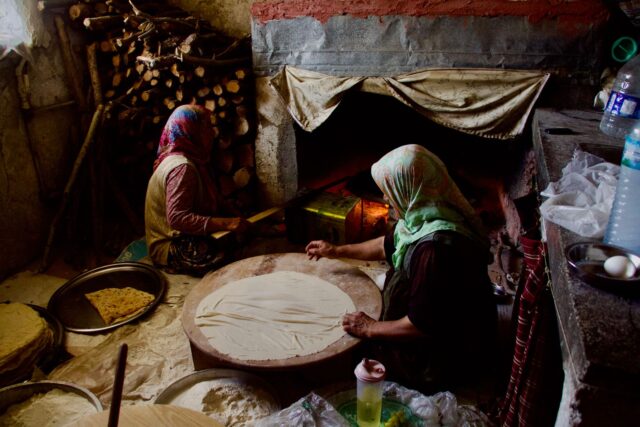 Algerian family preparing Bouzelouf dish