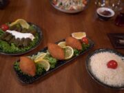 Le nouveau voyage gourmand s’ouvre à Saint-Jean-du-Falga : découvrez la gastronomie du Sud-Ouest français maghrébinisée Famille au diner dans un restaurant traditionnel du Sud-Ouest français avec des plats maghrébins sur la table
