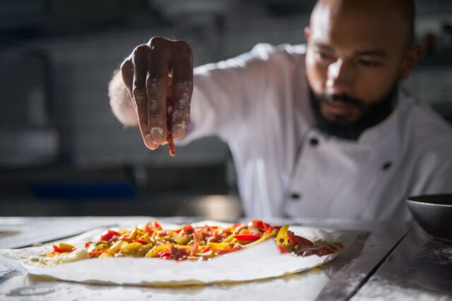 Mohamed Cheikh, Algerian Top Chef winner posing with culinary trophy and traditional Algerian dish