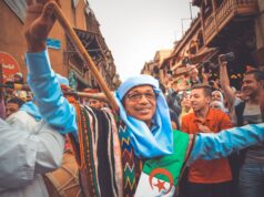 Organiser une fête folklorique pour l’Ami Fritz en Algérie : le guide pour un événement mémorable Famille et amis autour d'une table remplie de plats traditionnels algériens à une fête folklorique en plein air