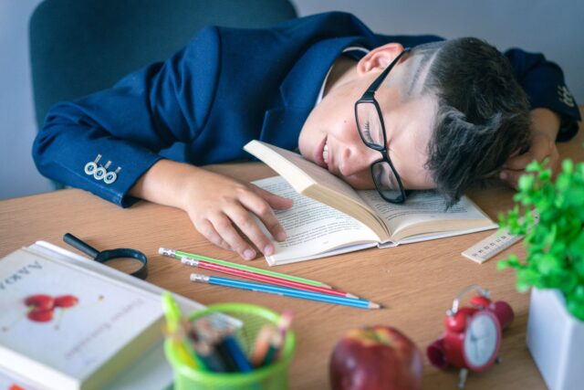 Enfant endormi dans son lit pendant la rentrée scolaire