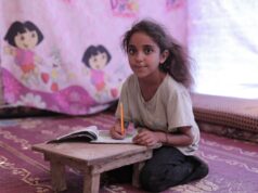 Le cas de l’enfant inscrit à Nîmes : les exigences scolaires et la participation régulière – Un appel à l’action pour les parents de la diaspora maghrébine Enfant maghrébin assis à une table de devoir avec des livres
