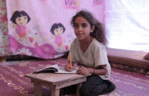 Le cas de l’enfant inscrit à Nîmes : les exigences scolaires et la participation régulière – Un appel à l’action pour les parents de la diaspora maghrébine Enfant maghrébin assis à une table de devoir avec des livres