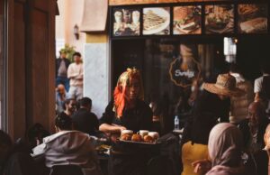 La famille au Maroc en mutation : des changements dans la société marocaine Famille au Maroc réunie à la table, en train de manger le couscous, changements dans la société marocaine dans le fond