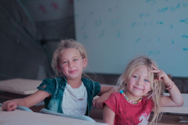 Enfants handicapés maghrébins en uniforme scolaire assis autour d'une table de cuisine traditionnelle algérienne