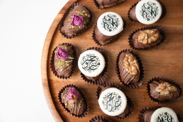 famille réunie autour d'une table avec des desserts traditionnels pour l'Aïd-el-Fitr
