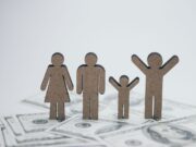 La Loi de Finances 2026 en Algérie : mesures pour le bien-être de la famille Algérien famille étendue discutant autour d'une table laden de couscous, sous le regard optimiste d'un enfant
