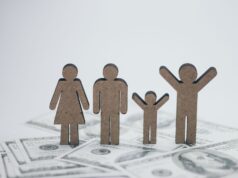 La Loi de Finances 2026 en Algérie : mesures pour le bien-être de la famille Algérien famille étendue discutant autour d'une table laden de couscous, sous le regard optimiste d'un enfant