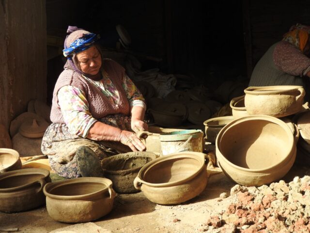 artisans marocains travaillant dans leur atelier avec des objets en céramique et de la broderie