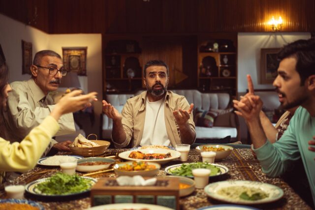 Maghrebin family discussion over traditional couscous Femme et enfants Maghrébins en conversation autour d'un tableau de couscous traditionnel